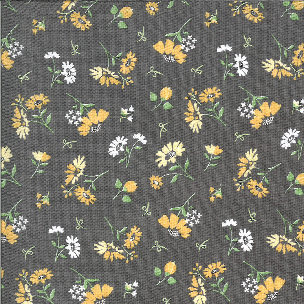 Corey Yoderin Spring Brook kokoelmasta Daisies Slate puuvillakangas, harmaa kangas, jossa pieniä valko-keltaisia kukkakuvioita.