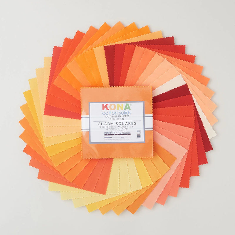 Kona Cotton Solids July Palette charm pack, 42 beigen, oranssin ja keltaisen sävyistä kangasneliötä viuhkana