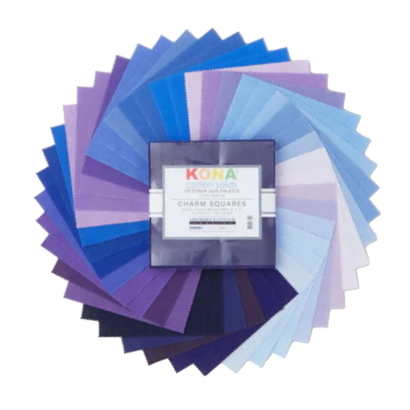 Kona Cotton Solids October Palette charm pack, 42 lilan ja sinisen sävyistä kangasneliötä viuhkana