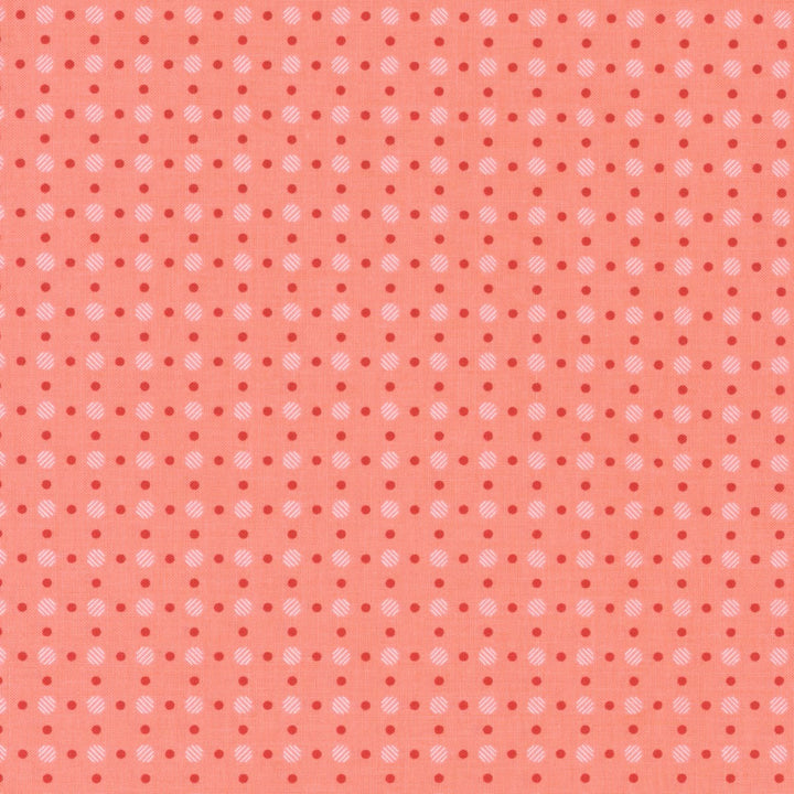 Koraalinväinen puuvillakangas, jossa punaisia ja vaaleanpunaisia täplä-muotoisia pisteitä Lori Holtin Bee Basics -kokoelmasta, ihanteellinen tilkkutöihin ja ompeluprojekteihin.