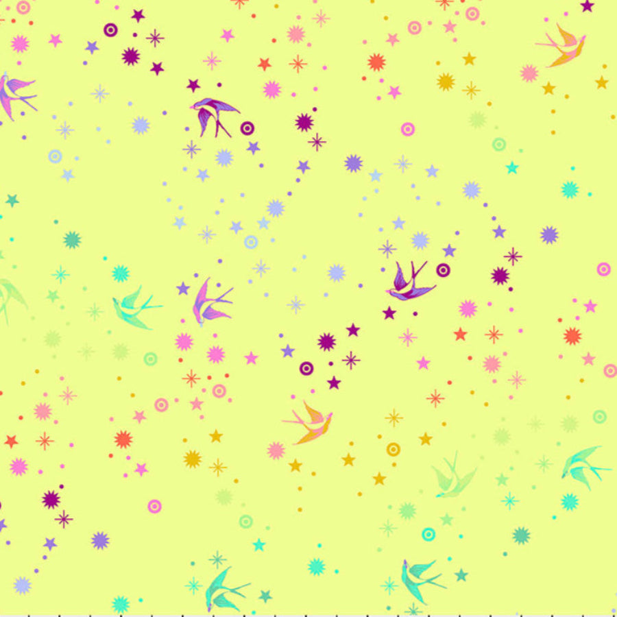 Tula Pink Fairy Dust Lime - puuvillakangas, jossa on sateenkaaren värisiä pääskysiä ja tähtikuvioita keltaisella pohjalla.