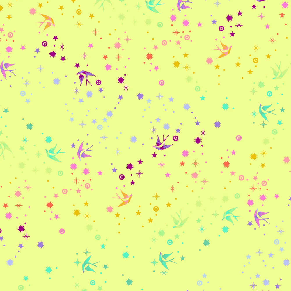 Tula Pink Fairy Dust Lime - puuvillakangas, jossa on sateenkaaren värisiä pääskysiä ja tähtikuvioita keltaisella pohjalla.