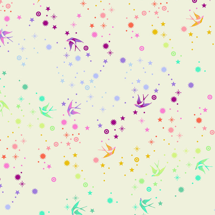 Tula Pink Fairy Dust Cotton Candy - puuvillakangas, jossa on sateenkaaren värisiä pääskysiä ja tähtikuvioita kermansävyisellä pohjalla.