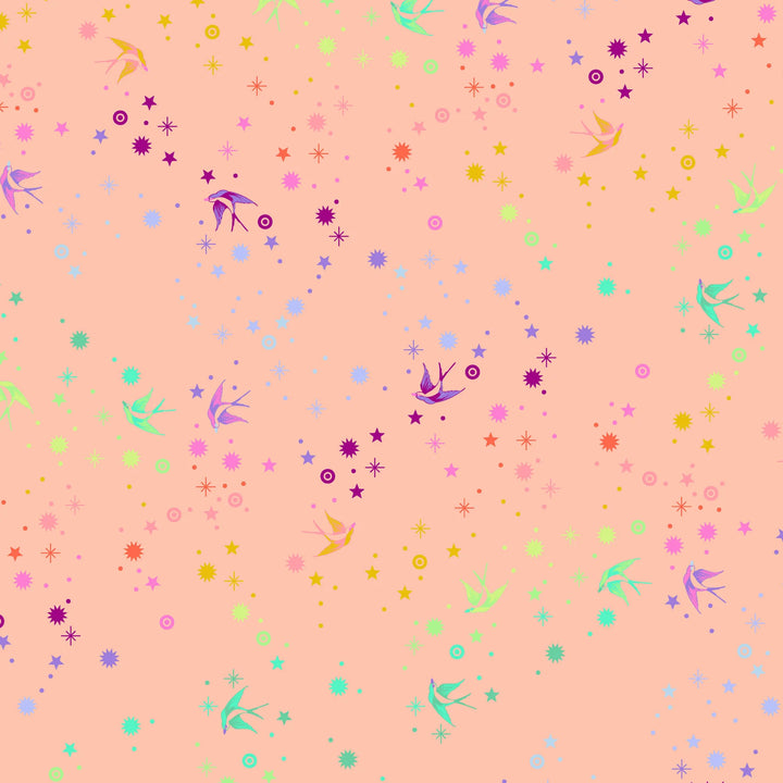 Tula Pink Fairy Dust Sherbet- puuvillakangas, jossa on sateenkaaren värisiä pääskysiä ja tähtikuvioita persikansävyisellä pohjalla.