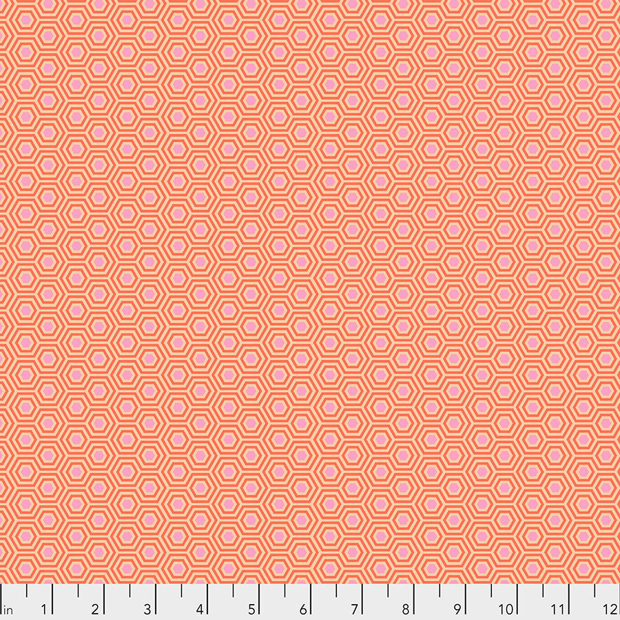 Tula Pink True Colors Hexy Peach Blossom  -kangas, persikan sävyinen pohja pastellisilla hexagon-kuvioilla.