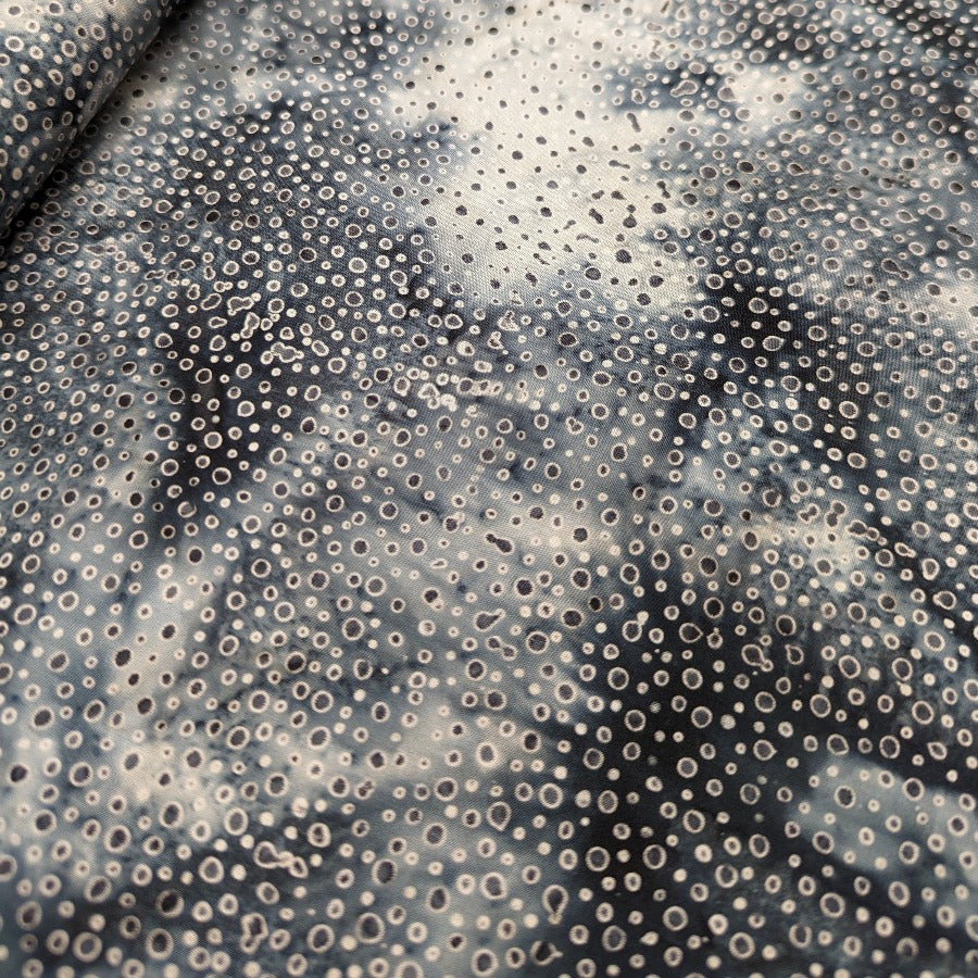 Volcano Bali Dots -batiikkipuuvillakangas, jossa elävä musta-harmaa kuosi ja pienet pisteet.