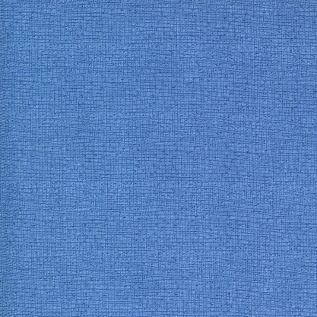 Robin Pickensin Thatched Cornflower -puuvillakangas, osa Cottage Bleu -kokoelmaa, tilkkutöihin ja käsitöihin.
Läheltä kuvattu Thatched-kuviointi: sinisen sävyt ja maalaisromanttinen tekstuuri.