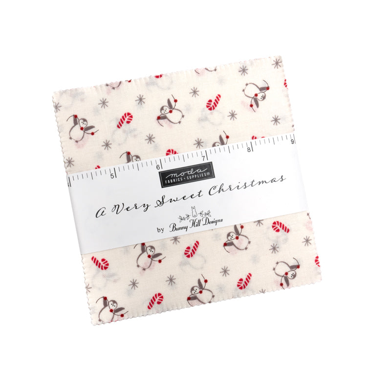 Bunny Hill Designs A Very Sweet Christmas 5" charm pack -kangasnippu, punaisen, harmaan ja vihreän sävyisiä kukka- ja ruutukuosisia puuvillaneliöitä ympyrässä.
