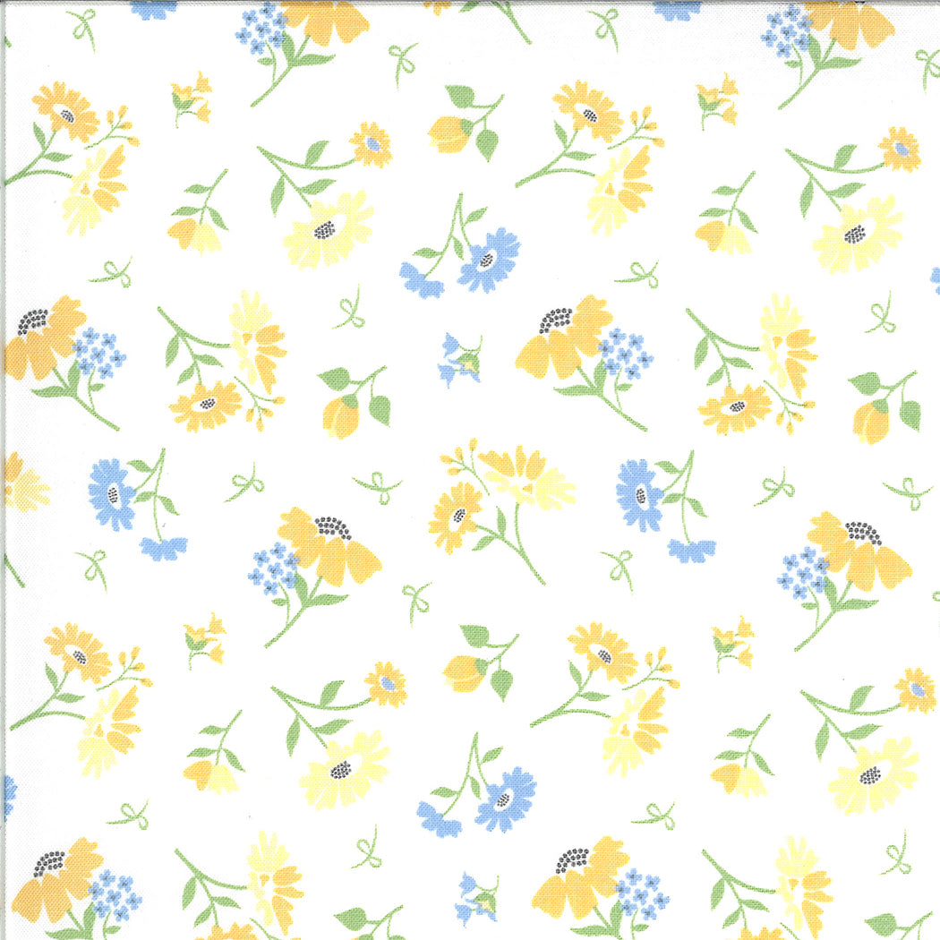 Corey Yoderin Spring Brook kokoelmasta Daisies Cloud puuvillakangas, valkoinen kangas, jossa pieniä sini-keltaisia kukkakuvioita.