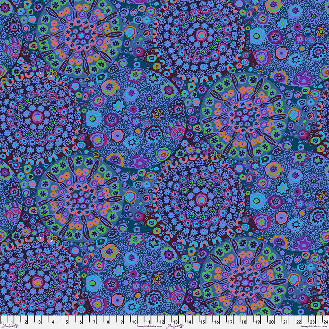 Lähikuva Kaffe Fassett Collectiven Millefiore Blue GP092.BLUE -puuvillakankaasta, jossa on yksityiskohtainen kukkakuviointi vaaleanpunaisen ja muiden sävyjen vivahteilla. Sopii täydellisesti tilkkutöihin ja ompeluun.