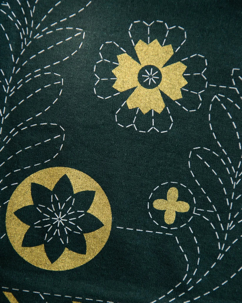 Vihreä-kultainen joulu-aiheinen sashiko-tyylinen kangaspaneeli, jossa geometrisia joulukuusikuvioita