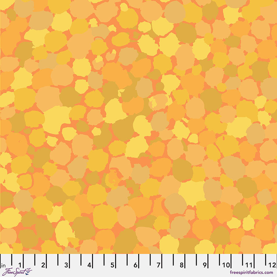 Kaffe Fassett Collective Reflections Yellow -puuvillakangas, jossa pilkkumainen kuvio keltaisen ja oraanssin sävyissä.