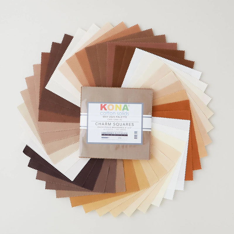 Kona Cotton Solids May Palette charm pack, 42 beigen ja ruskean sävyistä kangasneliötä viuhkana