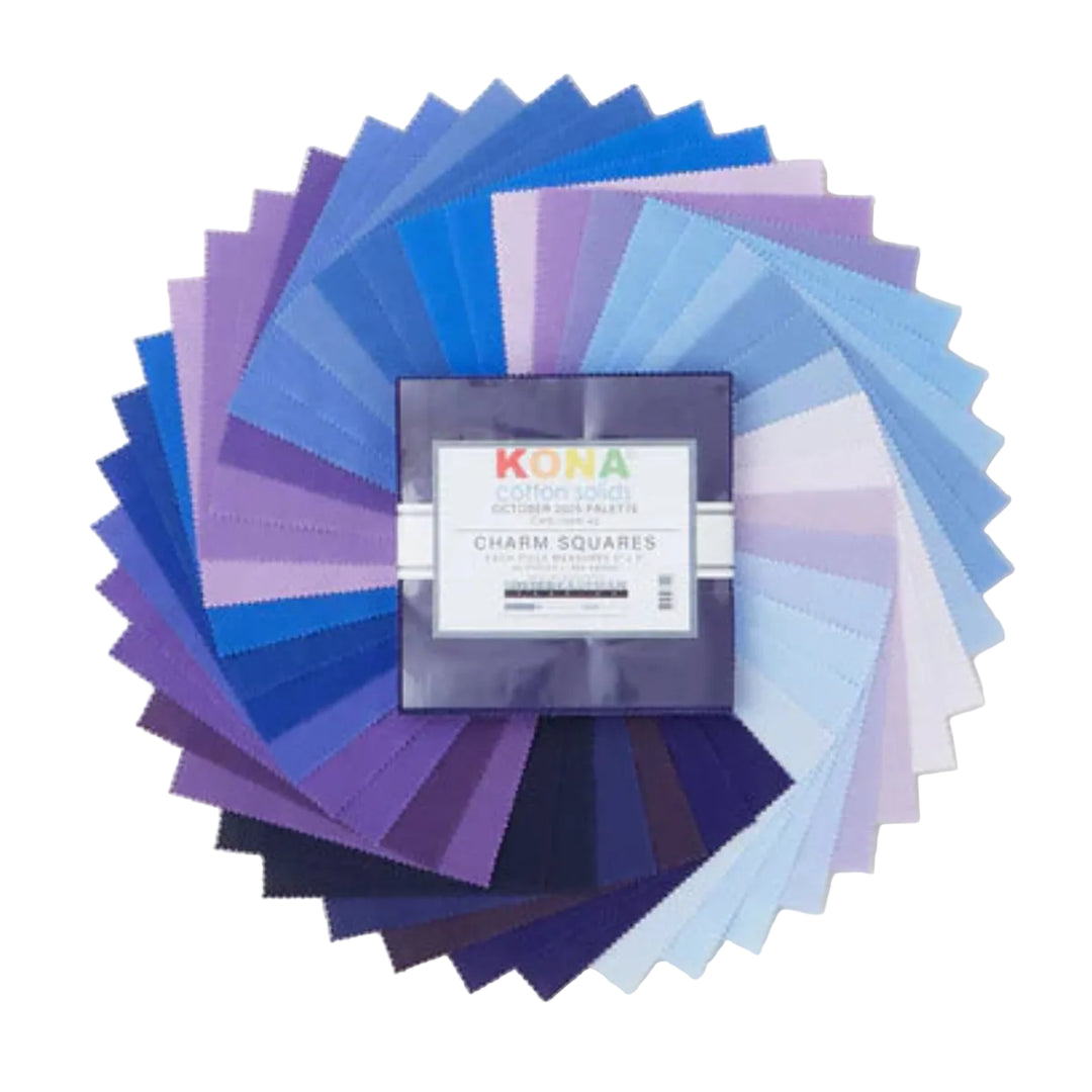 Kona Cotton Solids October Palette charm pack, 42 lilan ja sinisen sävyistä kangasneliötä viuhkana