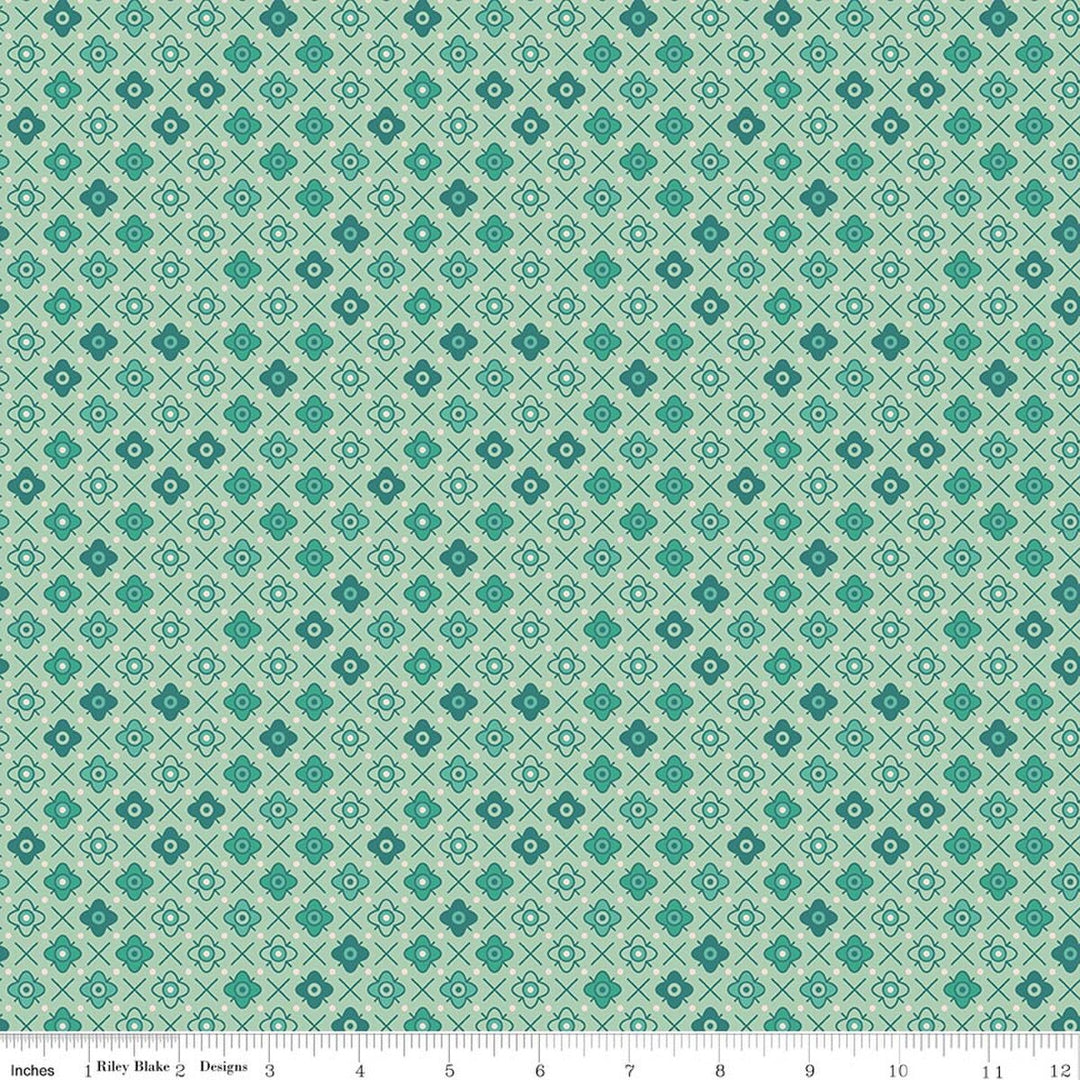 Lori Holtin Farmer's Daughter -kokoelman Flower Patch Sage -puuvillakangas. Vaaleanvihreä pohja, geometrisiä kukkakuvioita, sopii tilkkutöihin ja käsitöihin.