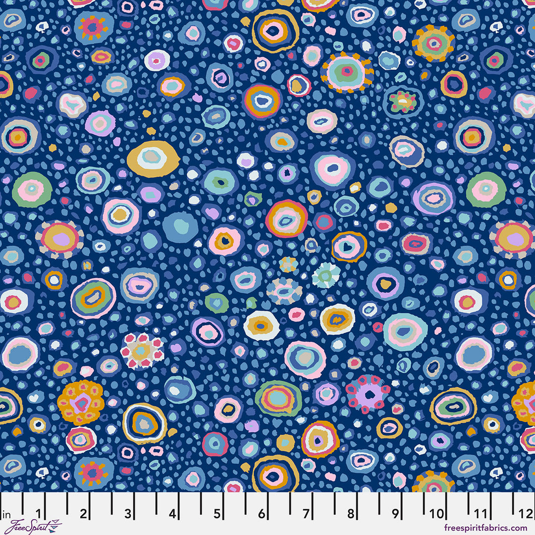 Kaffe Fassett Collective Roman Glass Blue PWGP001.BLUE puuvillakangas – tummansininen pohja ja kirkkaat konsentriset ympyräkuviot vihreänä, vaaleanpunaisena, oranssina.