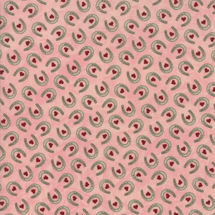 Vaaleanpunainen puuvillakangas, jossa hevosenkenkiä ja punaisia sydämiä – Sara Khammash Cowgirl Country 11304-16