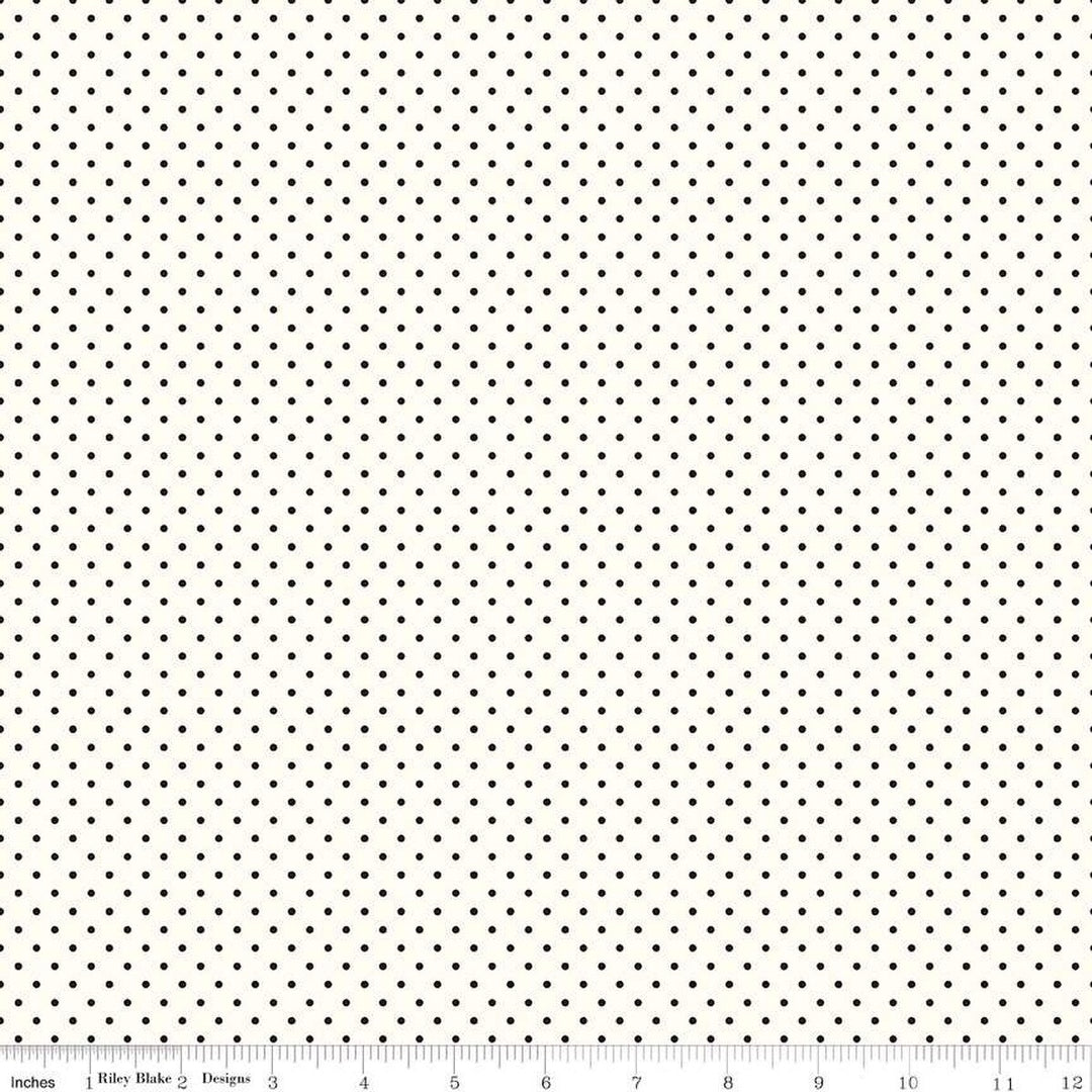 Riley Blake Swiss Dots -puuvillakangas, jossa pienet mustat pilkut kermaisella pohjalla, klassinen ja ajaton kuosi tilkkutöihin.