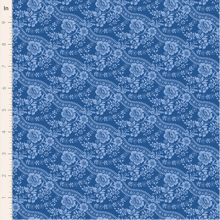 Tilda Something Blue Celeste Denim 110168 puuvillakangas, sininen tausta ja pitsimäinen kukkakuvio.