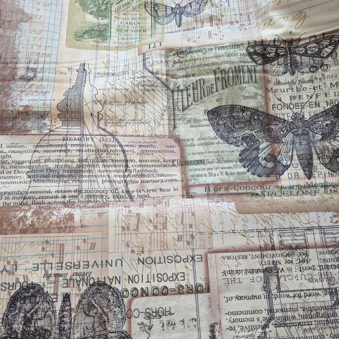 Tim Holtz Embark Melange Canvas -puuvillapanamakangas, jossa vintage-tyylisiä perhosia, tekstejä ja piirroskuvioita beigen ja harmaan sävyissä.