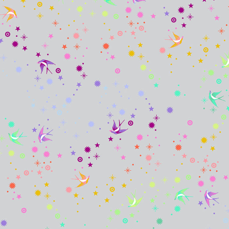 Tula Pinkin True Colors kokoelman Fairy Dust Fog - puuvillakangas, jossa on sateenkaaren värisiä pääskysiä ja tähtikuvioita vaaleanharmaalla pohjalla.