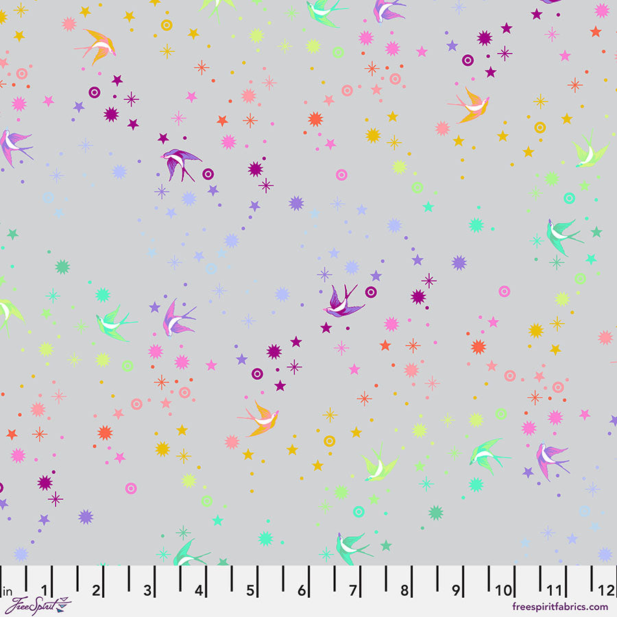 Tula Pinkin True Colors kokoelman Fairy Dust Fog - puuvillakangas, jossa on sateenkaaren värisiä pääskysiä ja tähtikuvioita vaaleanharmaalla pohjalla.