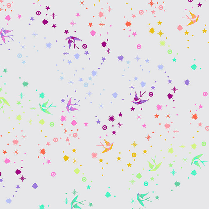 Tula Pink Fairy Dust Cotton Candy - puuvillakangas, jossa on sateenkaaren värisiä pääskysiä ja tähtikuvioita kermansävyisellä pohjalla.
