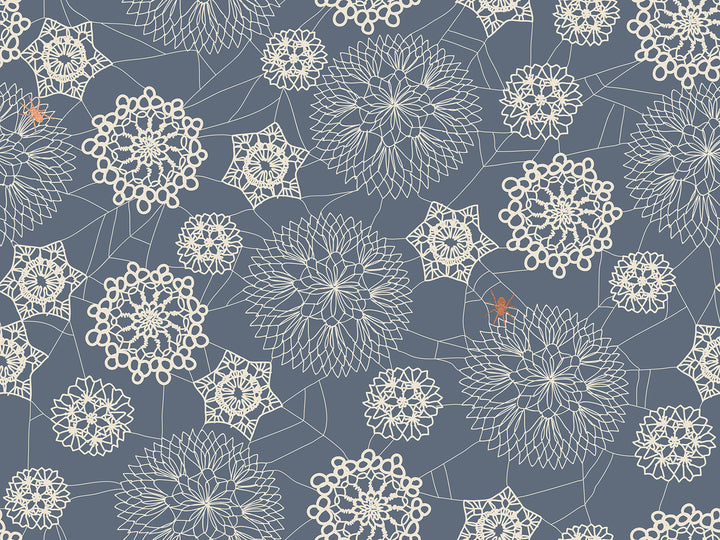 Harmaansinisellä pohjalla pitsimäisiä hämähäkinseittikuvioita ja oranssi hämähäkki, Ruby Star Society Spooky Darlings RS5076-16M Metallic Doily Spider Web Ghostly puuvillakangas.
