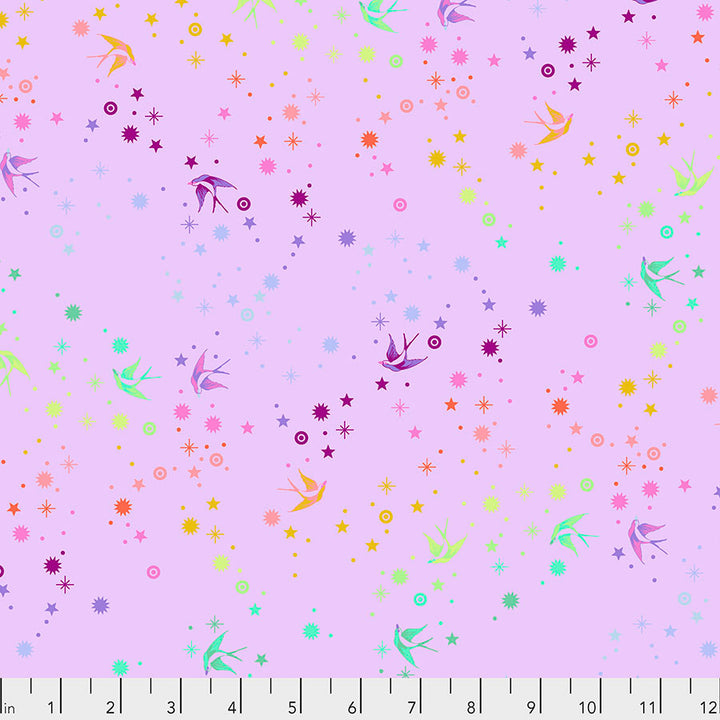Tula Pink Fairy Dust Sherbet- puuvillakangas, jossa on sateenkaaren värisiä pääskysiä ja tähtikuvioita lilansävyisellä pohjalla.